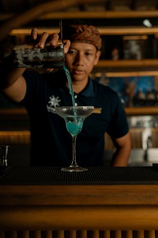 Man serves cocktail at Roost Rooftop Restaurant Nusa Dua